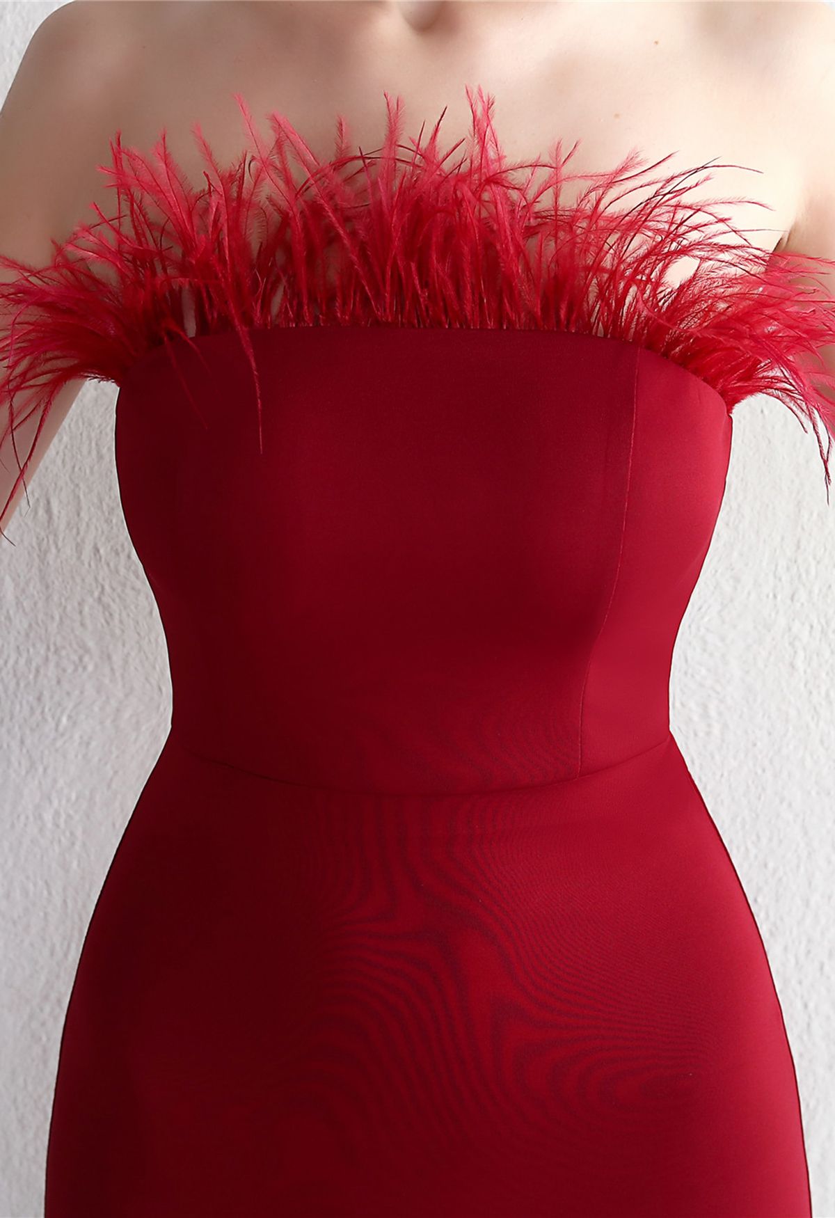 Trägerloses, geschlitztes Kleid mit Federbesatz in Rot